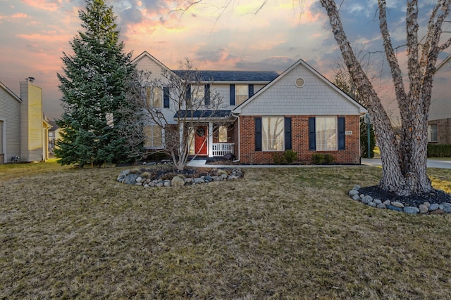 view of front of house with a front yard and brick siding