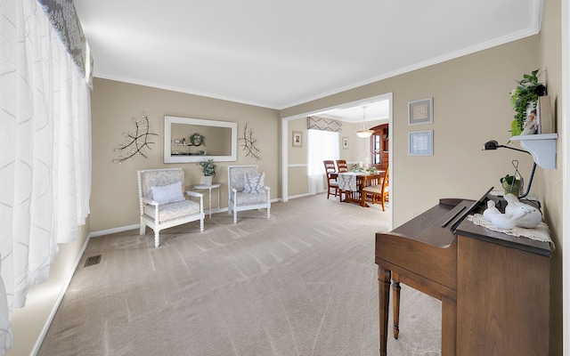 sitting room with visible vents, baseboards, carpet flooring, and crown molding