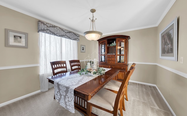 dining space with baseboards, light colored carpet, and crown molding