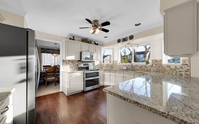 kitchen with a sink, crown molding, and stainless steel appliances