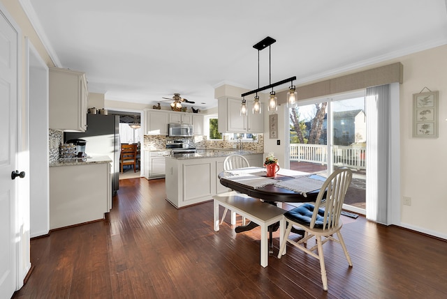 dining area with a ceiling fan, dark wood-style flooring, and crown molding