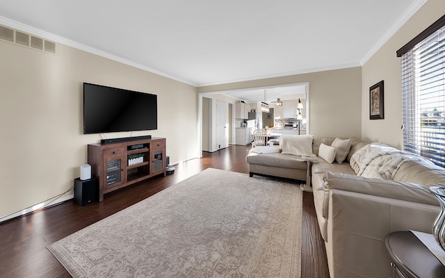 living room featuring visible vents, dark wood-type flooring, and ornamental molding