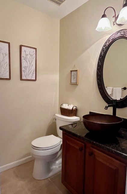 bathroom featuring vanity, tile patterned floors, toilet, and baseboards