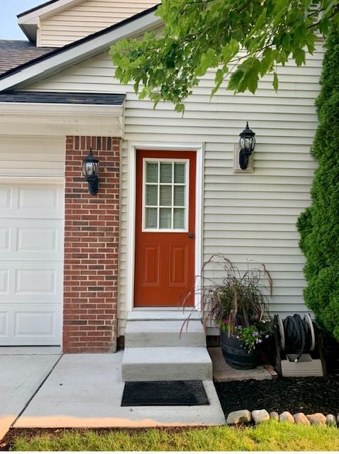 entrance to property with brick siding and an attached garage