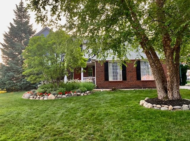 exterior space featuring a yard and brick siding