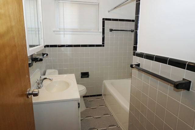 bathroom with toilet, vanity, bathing tub / shower combination, tile patterned floors, and tile walls