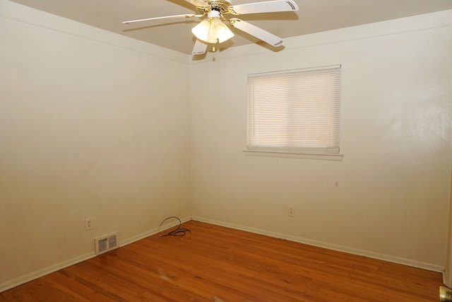 spare room with visible vents, baseboards, ceiling fan, and wood finished floors