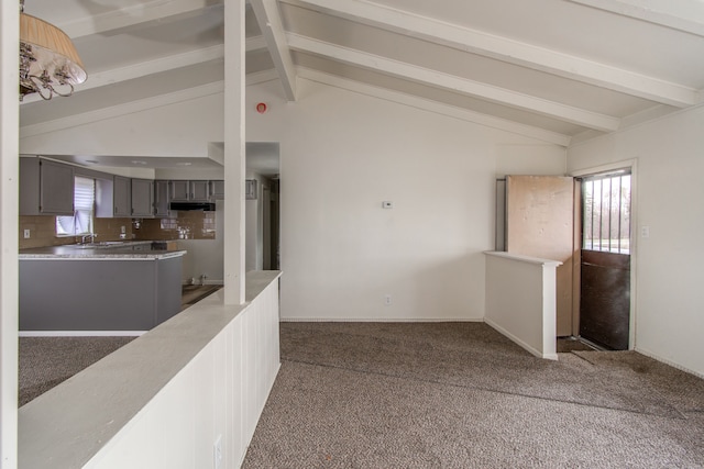 interior space with lofted ceiling with beams and a sink