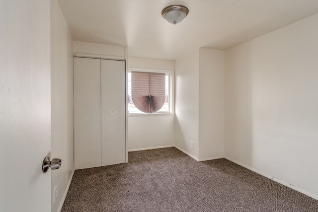 unfurnished bedroom with carpet flooring, baseboards, and a closet