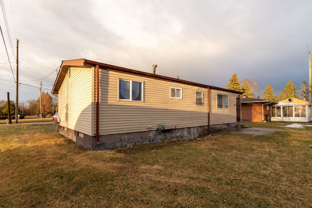 view of home's exterior featuring a yard and a sunroom