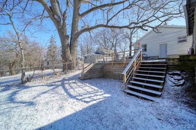 yard layered in snow with a deck, stairs, and fence