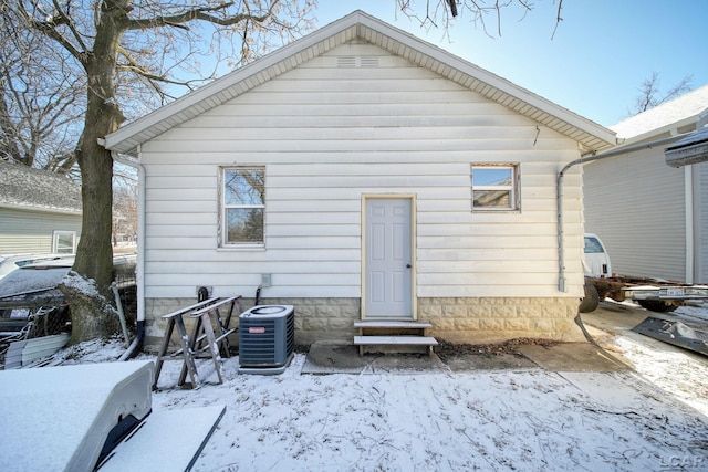 snow covered house featuring cooling unit