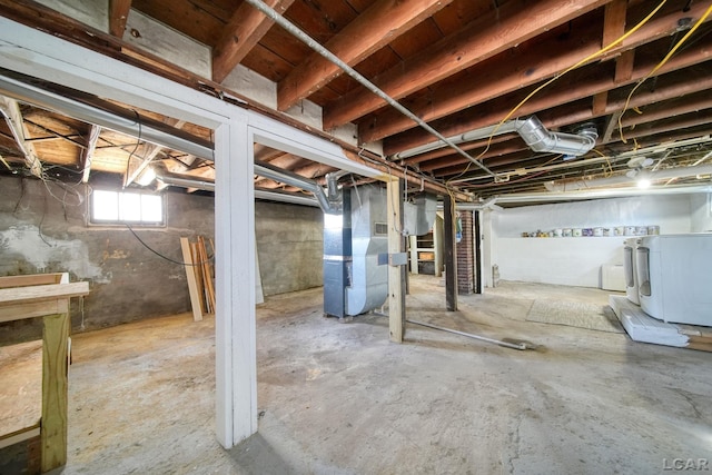 basement featuring heating unit and washing machine and dryer