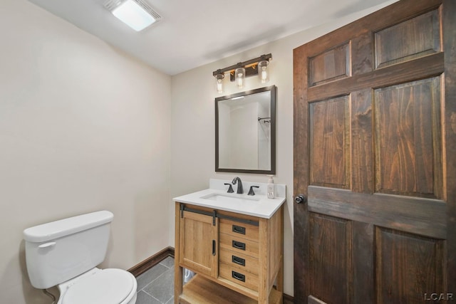 bathroom featuring baseboards, toilet, vanity, and tile patterned flooring