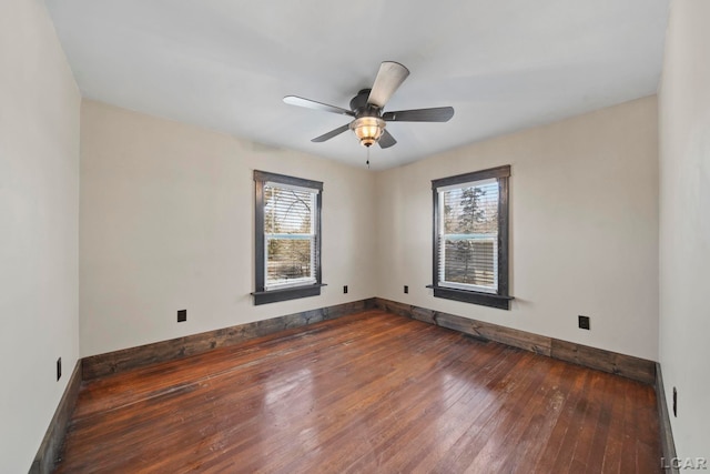 empty room with wood-type flooring, baseboards, and a wealth of natural light