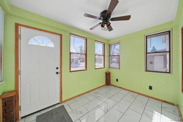 entrance foyer featuring marble finish floor, a ceiling fan, and baseboards