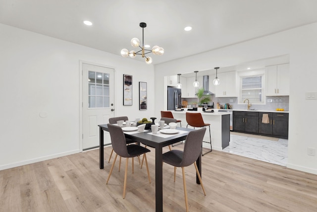 dining area with light wood finished floors, a chandelier, recessed lighting, and baseboards