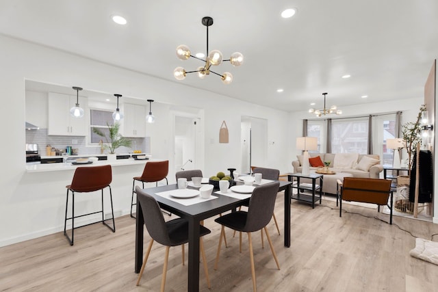 dining area featuring light wood finished floors, a notable chandelier, and recessed lighting