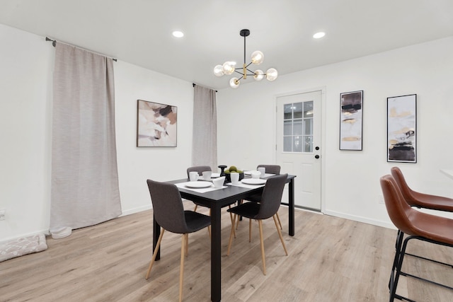 dining room with recessed lighting, light wood-style flooring, an inviting chandelier, and baseboards