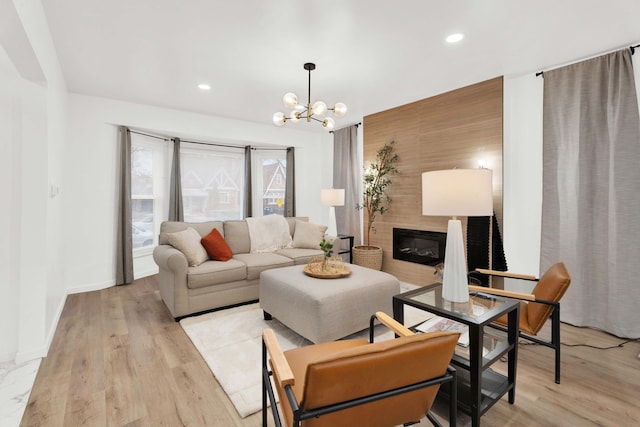 living room with baseboards, an inviting chandelier, light wood-style flooring, recessed lighting, and a fireplace