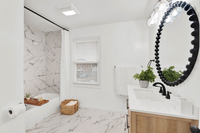 bathroom featuring marble finish floor, vanity, baseboards, and shower / bath combo