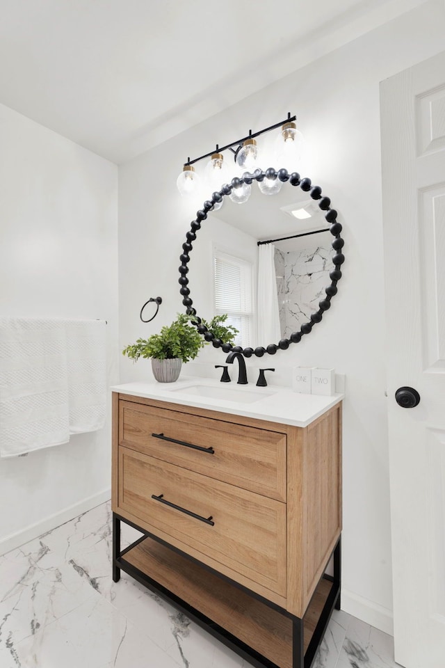 bathroom with baseboards, marble finish floor, and vanity