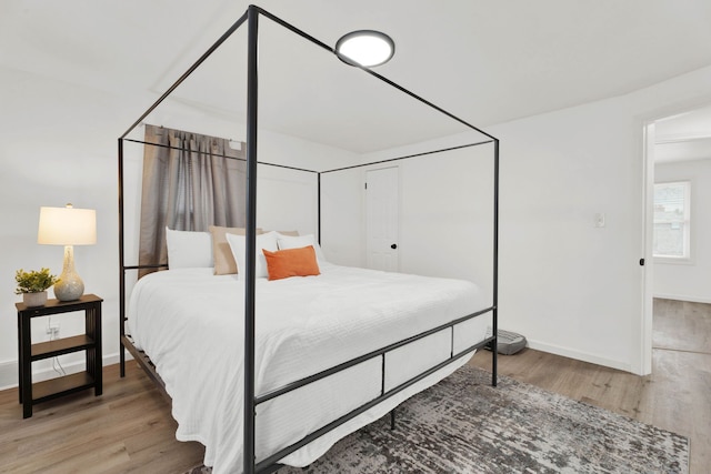 bedroom with a closet, baseboards, and wood finished floors