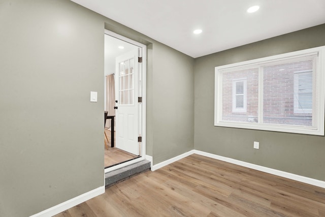 empty room with recessed lighting, baseboards, and wood finished floors