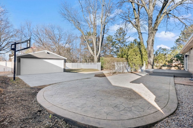 view of yard featuring a garage, a patio, an outbuilding, and fence