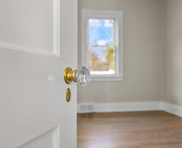 room details featuring visible vents, baseboards, and wood finished floors