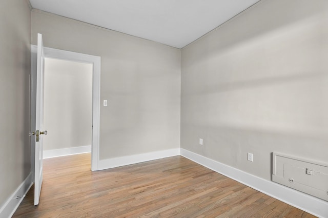 empty room featuring light wood-type flooring and baseboards