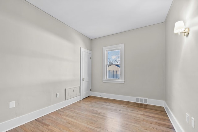 empty room featuring visible vents, light wood-style flooring, and baseboards