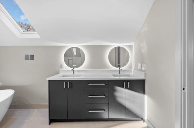 bathroom with double vanity, a soaking tub, visible vents, and a sink