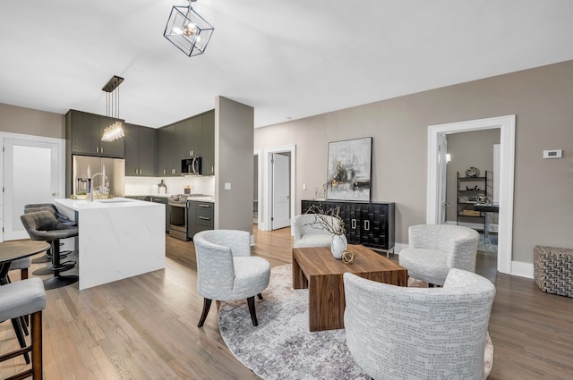 living area featuring baseboards and light wood finished floors