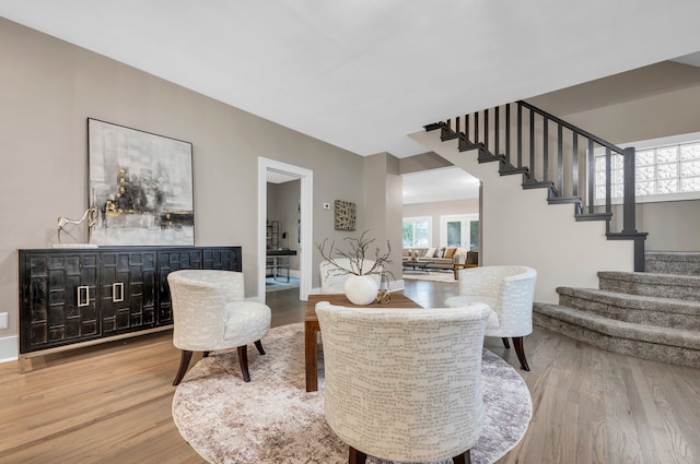 living area featuring baseboards, stairs, and wood finished floors