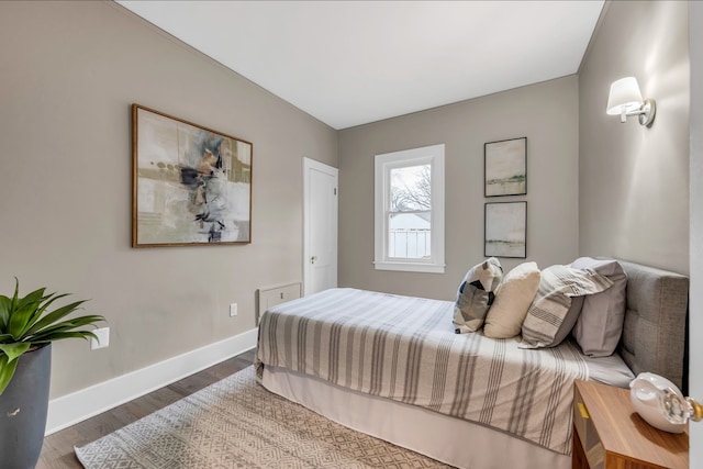 bedroom with baseboards and wood finished floors