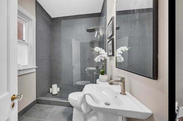 full bathroom featuring a sink, toilet, tile patterned flooring, and walk in shower