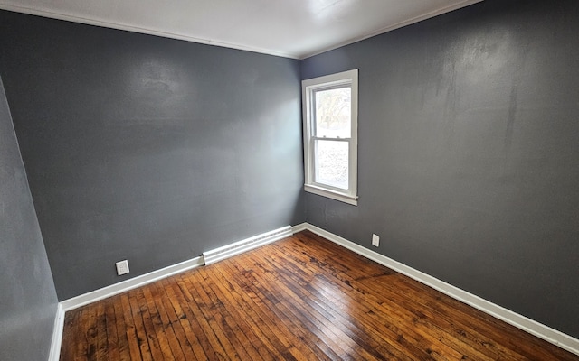 spare room with baseboard heating, baseboards, and dark wood-style flooring