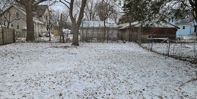 snowy yard featuring a fenced backyard