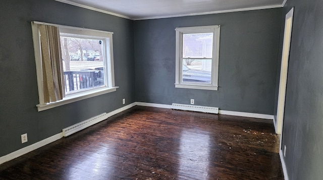 spare room featuring a baseboard heating unit, baseboards, and dark wood-style flooring