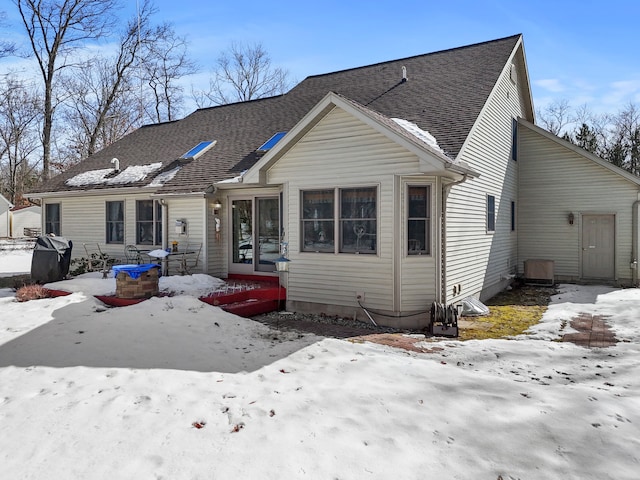 bungalow-style home with roof with shingles