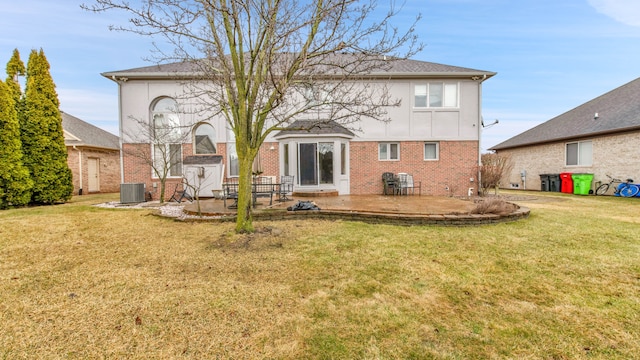 back of property with a yard, a patio, brick siding, and board and batten siding