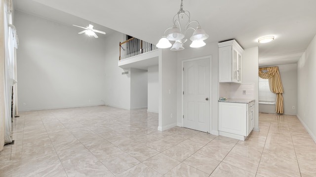 kitchen with ceiling fan with notable chandelier, decorative light fixtures, white cabinetry, light countertops, and baseboards