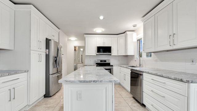 kitchen with white cabinetry, decorative backsplash, appliances with stainless steel finishes, and a sink