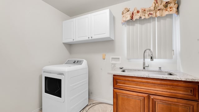 washroom featuring washer / dryer, cabinet space, baseboards, and a sink