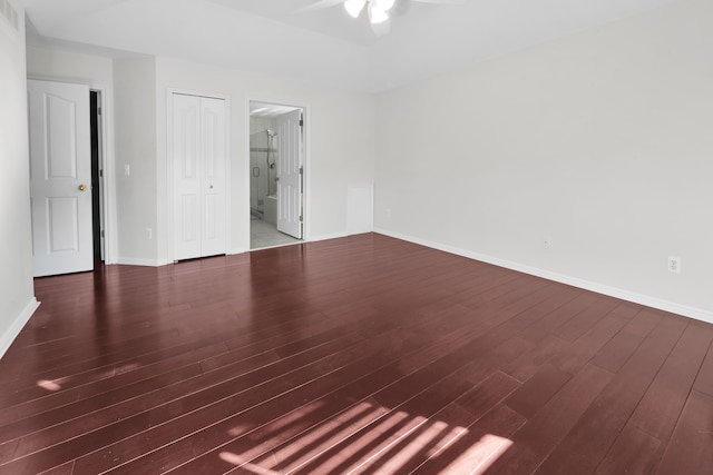 unfurnished bedroom with visible vents, ensuite bathroom, wood finished floors, a closet, and baseboards