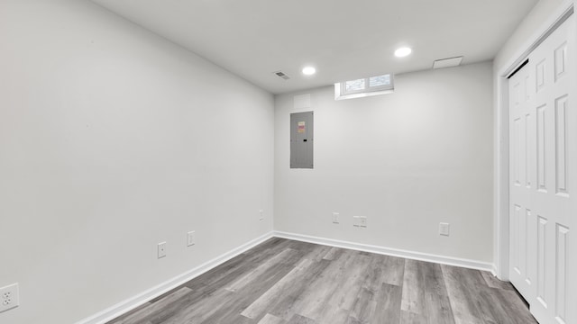 unfurnished bedroom featuring wood finished floors, visible vents, baseboards, electric panel, and a closet