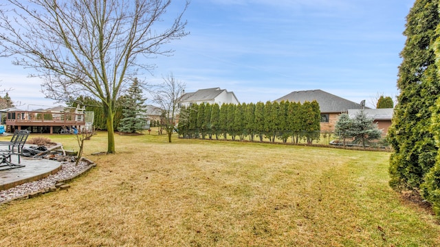 view of yard with a wooden deck and a patio