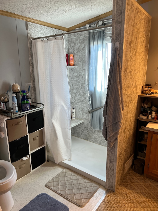 full bath featuring a shower stall and a textured ceiling