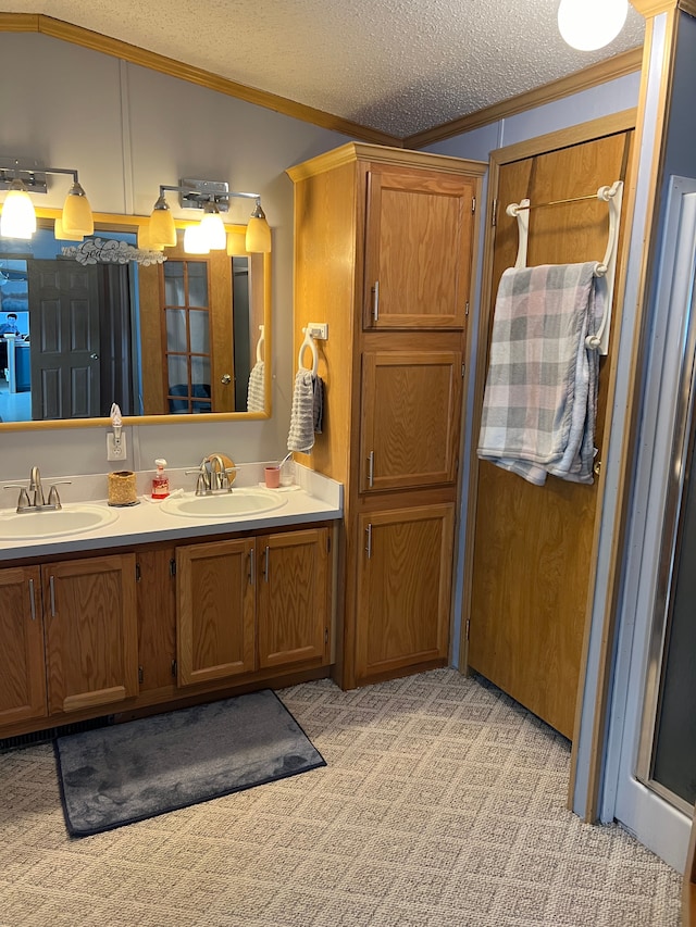 bathroom featuring a sink, lofted ceiling, a textured ceiling, and ornamental molding